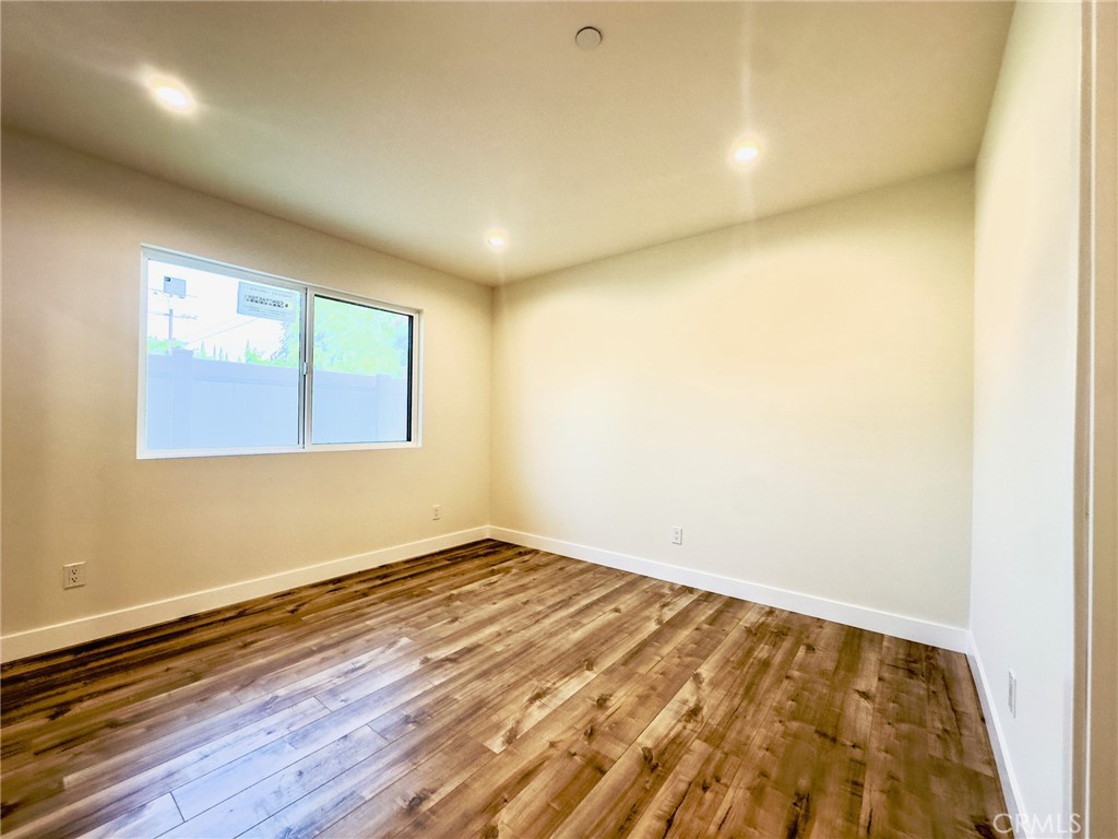 15952 Cohasset Street Van Nuys, CA 91406 - Photo 8 of 11 an empty room with wooden floor and windows