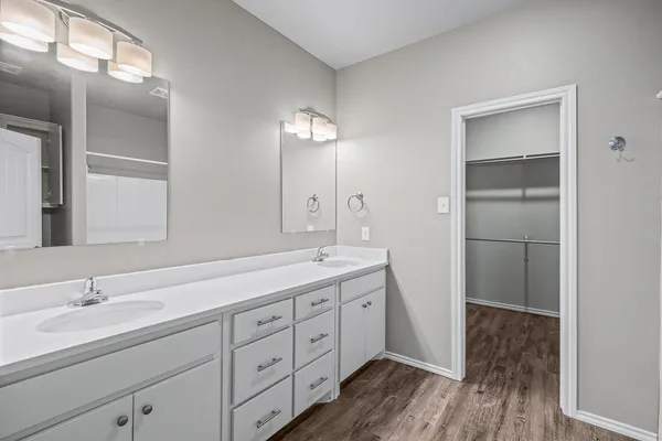 a spacious bathroom with a double vanity sink and mirror