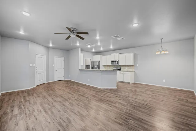 a view of kitchen with kitchen island wooden floor center island and appliances