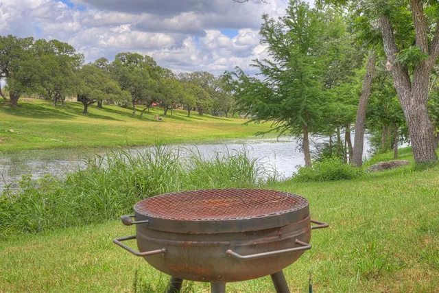 a view of a backyard with table and chairs and a lake view