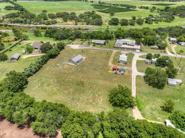 an aerial view of residential houses with outdoor space and river