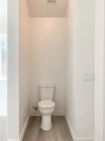 a white toilet sitting next to a white cabinet
