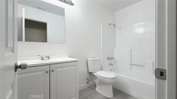 a bathroom with a granite countertop toilet a sink and a mirror