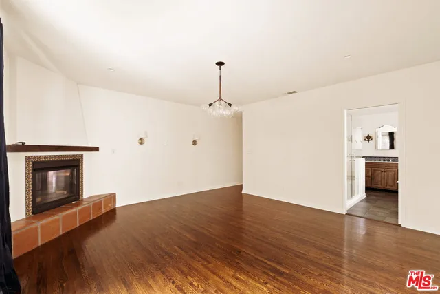 a view of a livingroom with wooden floor and a fireplace
