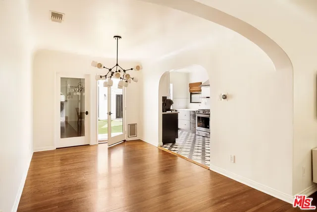 a view of a kitchen with a chandelier wooden floor and a chandelier