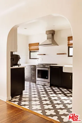 a living room with stainless steel appliances kitchen island granite countertop a stove and a refrigerator