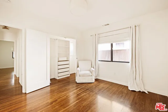 a bedroom with a white bed and a window