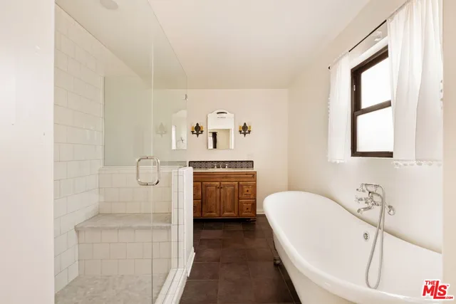 a bathroom with a granite countertop bathtub sink and mirror