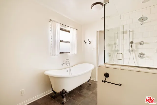 a bathroom with a sink and mirror with bathtub