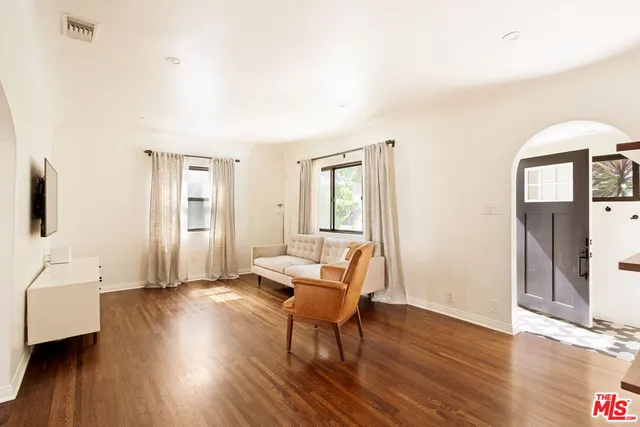 a living room with furniture and a wooden floor