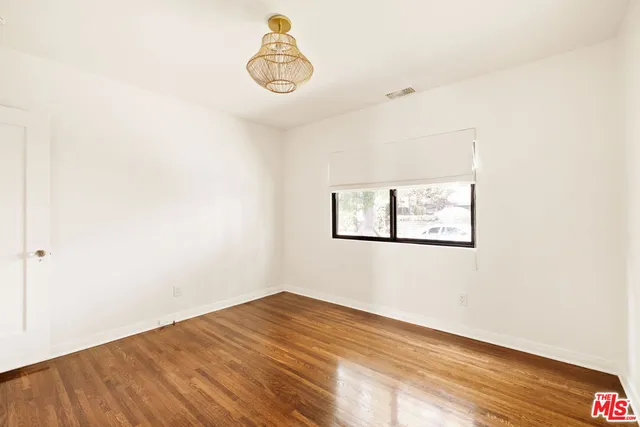 a view of a room with wooden floor and ceiling fan