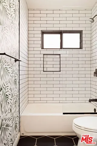 a bathroom with a bathtub and next to a window
