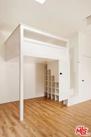 a view of empty room with wooden floor and window