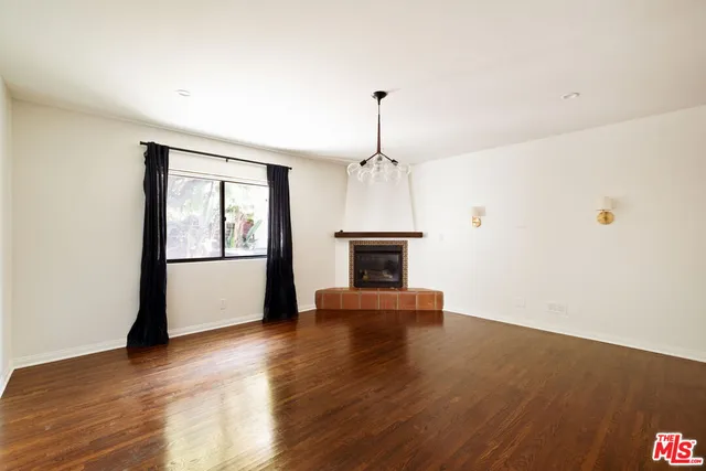 a view of empty room with wooden floor and fireplace