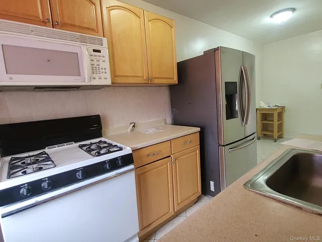 a kitchen with stainless steel appliances a stove a refrigerator and a sink