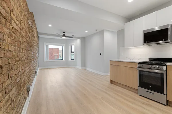 a view of a kitchen with a sink stove cabinets and empty room