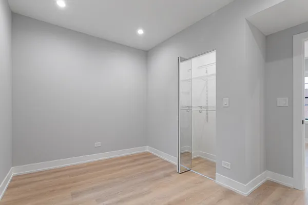 an empty room with wooden floor and door