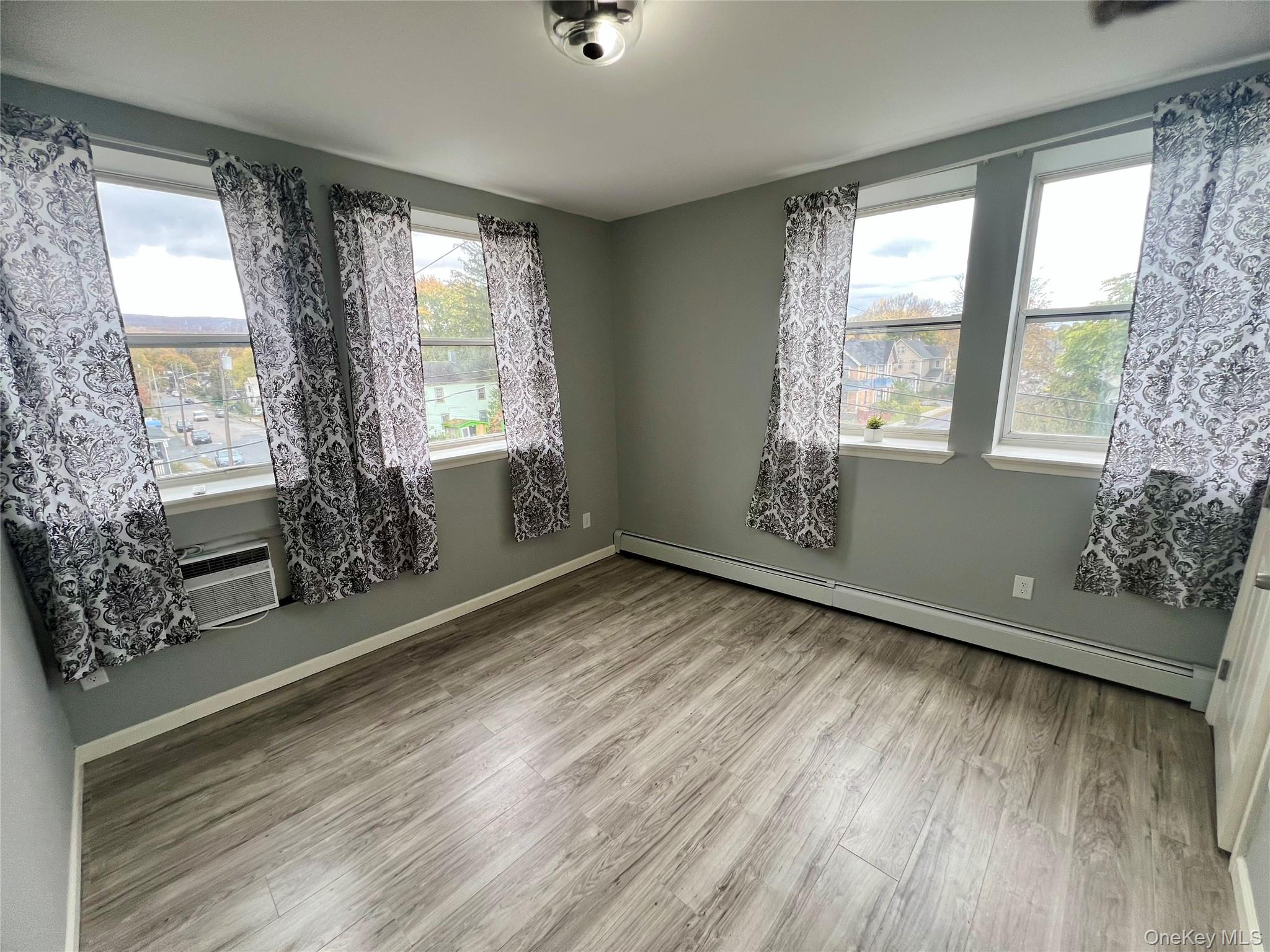 39 Church Street, Unit 53 Port Jervis, NY 12771 - Photo 14 of 32 a view of an empty room with wooden floor and a window