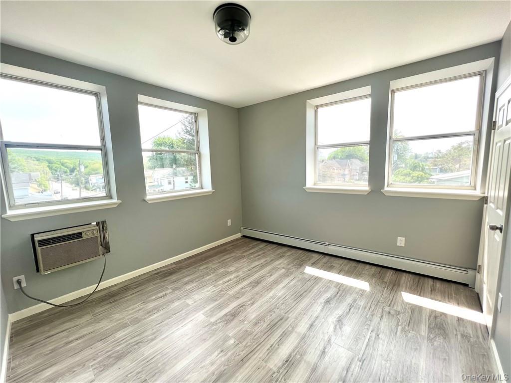 39 Church Street, Unit 53 Port Jervis, NY 12771 - Photo 17 of 32 a view of an empty room with a window and wooden floor