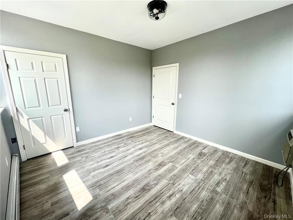 39 Church Street, Unit 53 Port Jervis, NY 12771 - Photo 18 of 32 an empty room with wooden floor cabinet and windows
