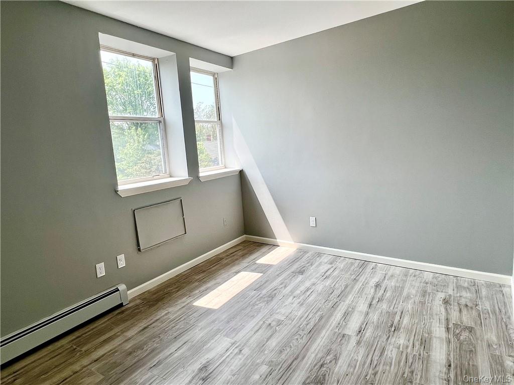 39 Church Street, Unit 53 Port Jervis, NY 12771 - Photo 20 of 32 an empty room with wooden floor and windows