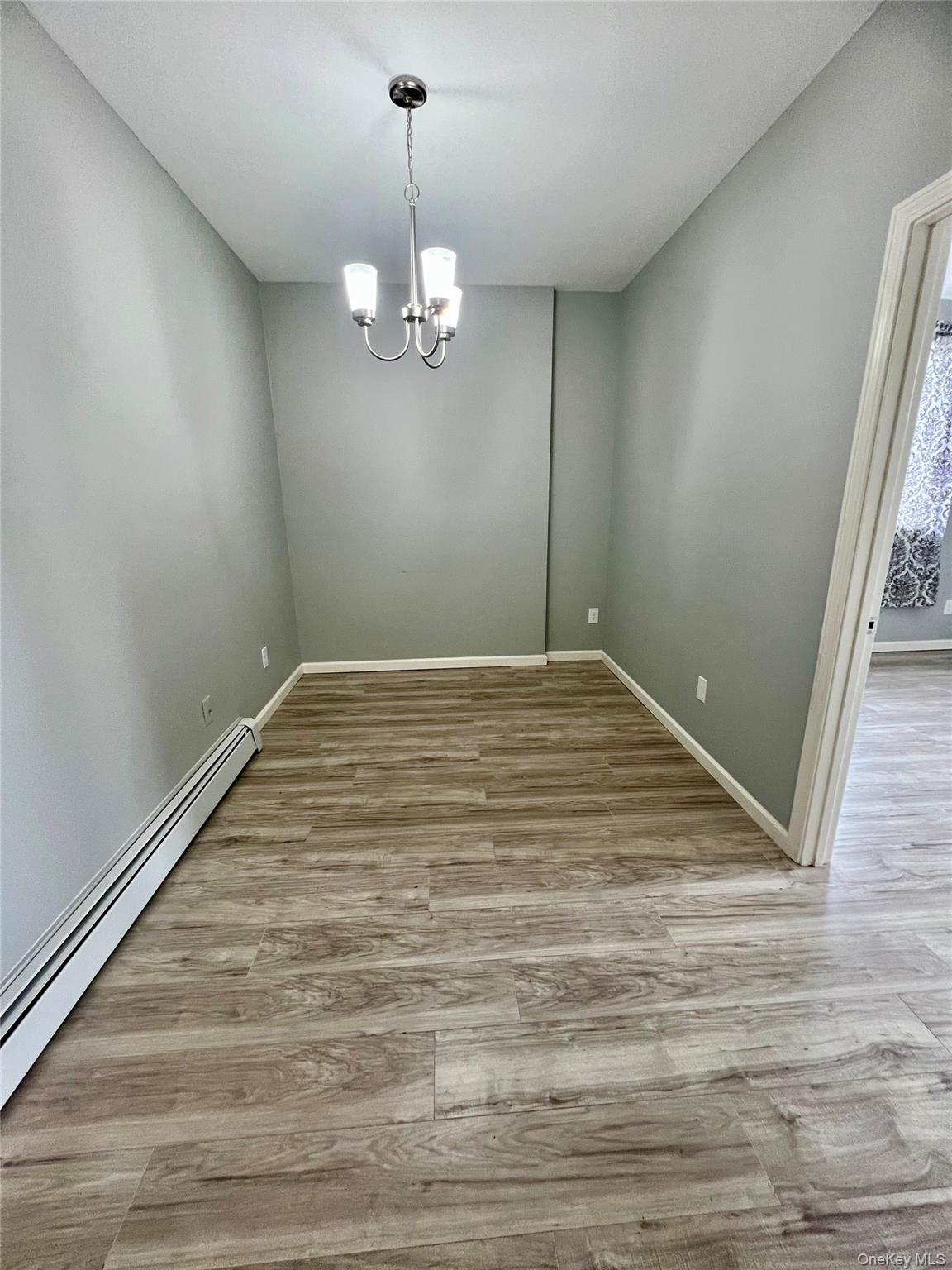 39 Church Street, Unit 53 Port Jervis, NY 12771 - Photo 9 of 32 a view of empty room with wooden floor and chandelier