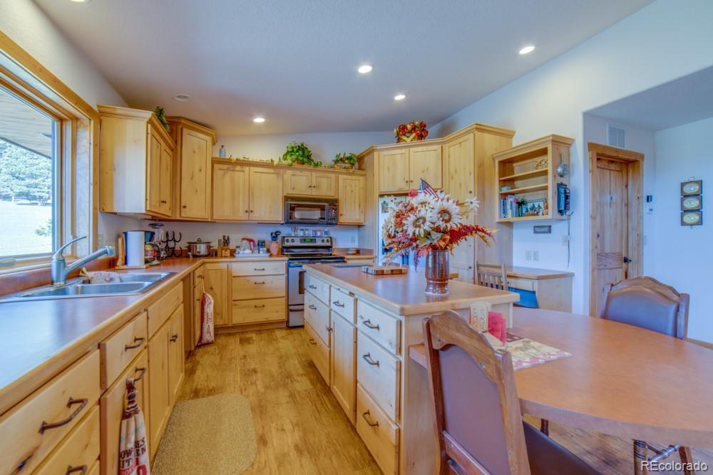 8615 Highway 165 Rye, CO 81069 - Photo 15 of 37 a kitchen with stainless steel appliances granite countertop a sink dishwasher stove refrigerator and couches with wooden floor