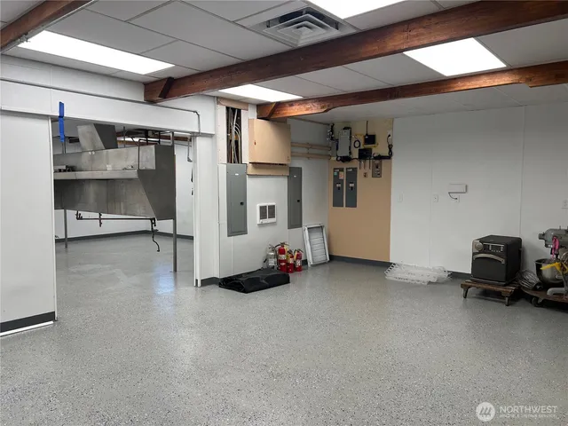 a view of a hallway with wooden floor and windows in a kitchen