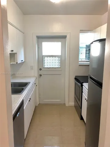 a kitchen with a sink a refrigerator and window
