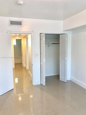 a view of hallway with walk in closet and a window