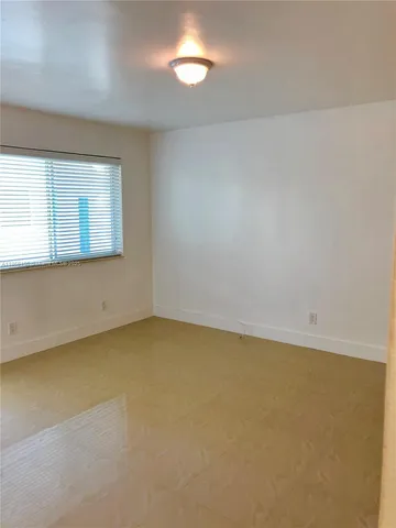 a view of a hallway with wooden floor and windows