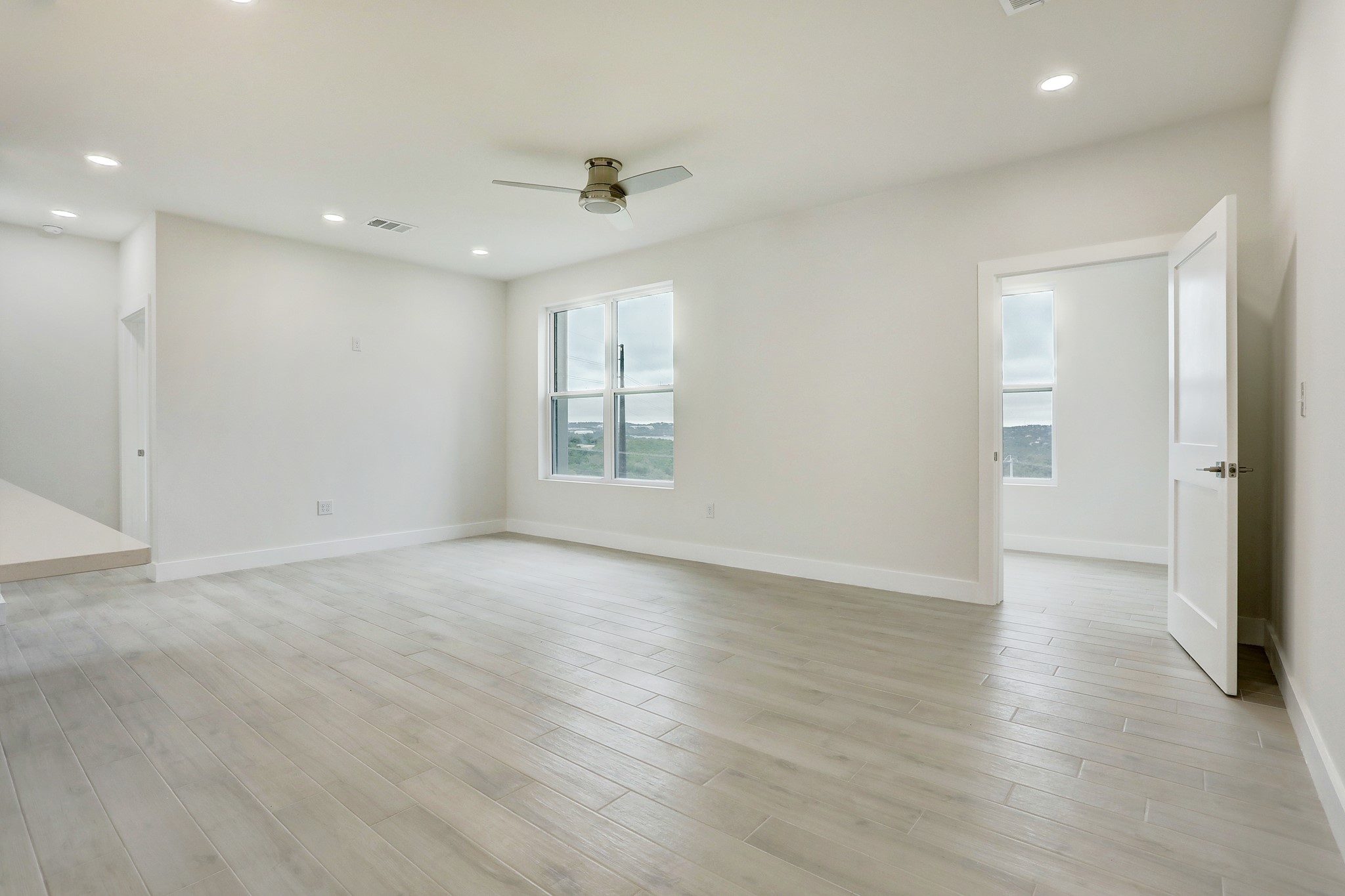 4300 Mansfield Dam Road, Unit 531 Austin, TX 78734 - Photo 11 of 32 Recessed lighting and wood-look flooring enhance this light-filled room with scenic exterior views.
