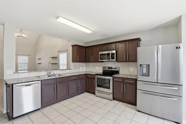 a kitchen with a sink white cabinets and stainless steel appliances