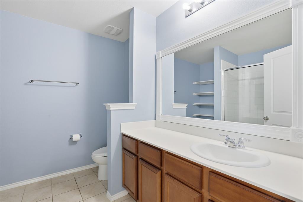 3035 Seth Lane Forney, TX 75126 - Photo 16 of 31 a bathroom with a sink a toilet a mirror and vanity