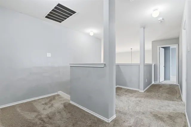 an empty room with wooden floor and bathroom