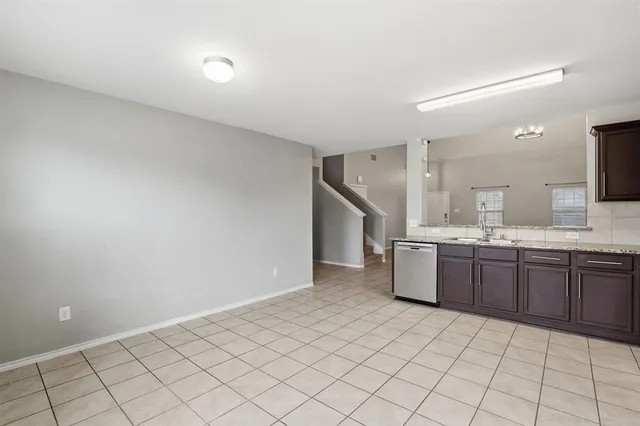 a large white kitchen with a sink and dishwasher