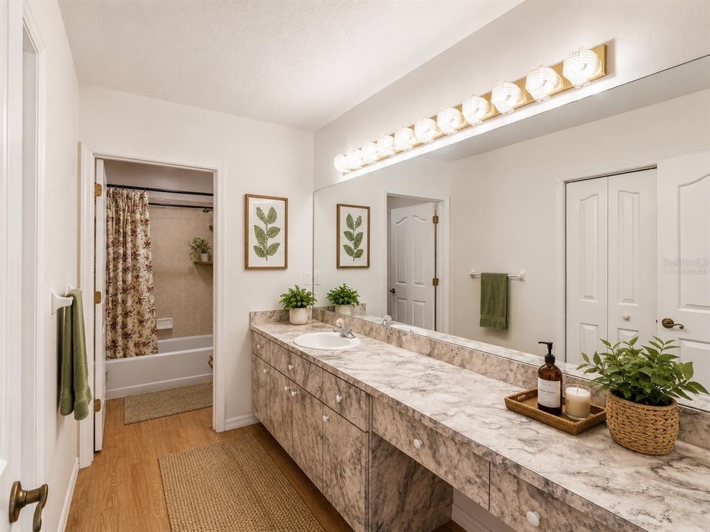 15420 Aubrey Avenue Spring Hill, FL 34610 - Photo 21 of 28 a bathroom with a granite countertop sink a large mirror and shower