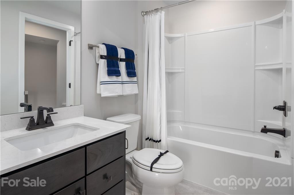 945 Portrush Lane, Unit 1011E Tega Cay, SC 29708 - Photo 2 of 12 a bathroom with a sink a toilet and shower