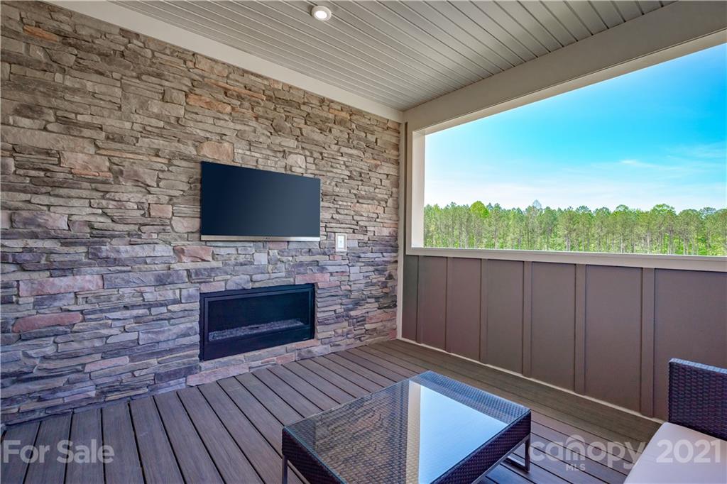 945 Portrush Lane, Unit 1011E Tega Cay, SC 29708 - Photo 12 of 12 a living room with furniture wooden floor and a fireplace