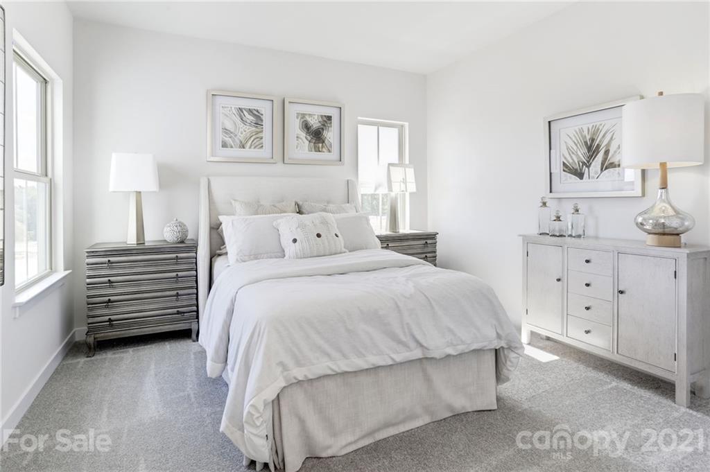 945 Portrush Lane, Unit 1011E Tega Cay, SC 29708 - Photo 9 of 12 a bedroom with a bed and a night stand