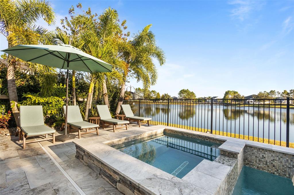 14822 Trails Edge Boulevard Odessa, FL 33556 - Photo 22 of 73 a view of a lake with couches chairs under an umbrella