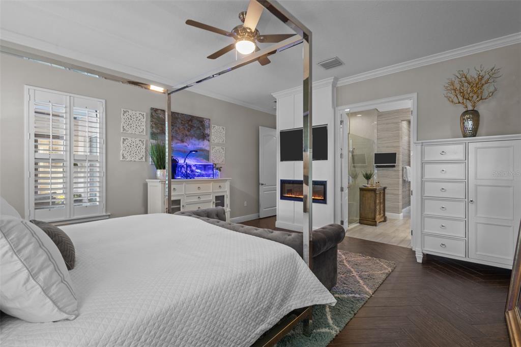 14822 Trails Edge Boulevard Odessa, FL 33556 - Photo 26 of 73 a bedroom with a large bed a flat screen tv and chandelier