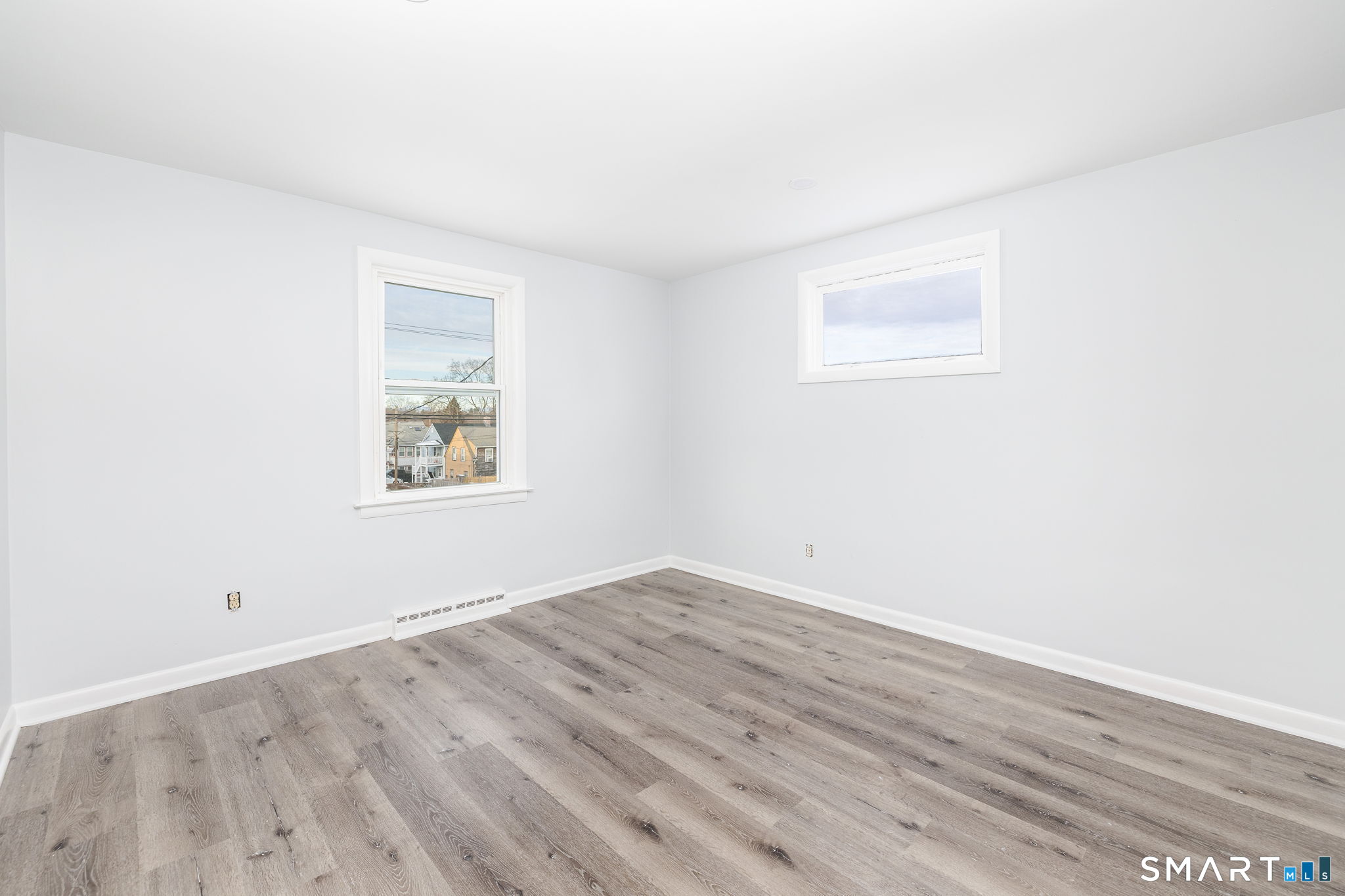 153 Gridley Street Bristol, CT 06010 - Photo 8 of 14 an empty room with wooden floor and windows