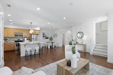 a kitchen with a dining table chairs and refrigerator