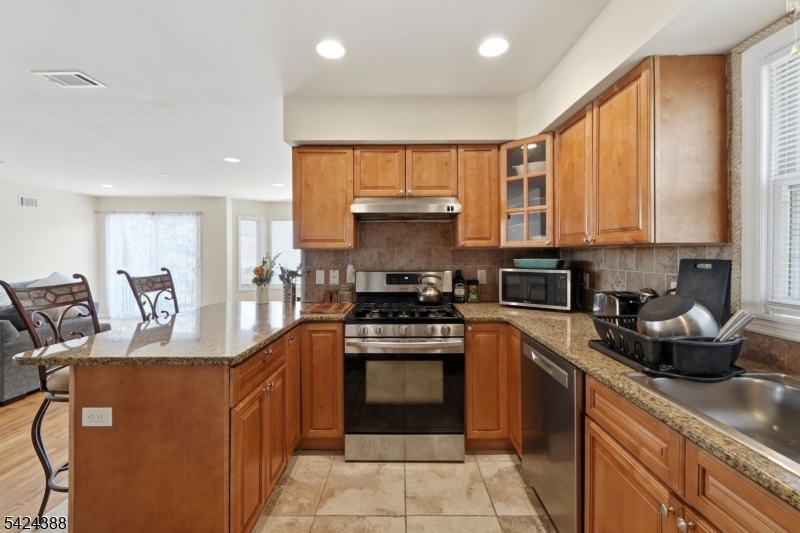 433 Linden Avenue Elizabeth, NJ 07202 - Photo 18 of 33 a kitchen with stainless steel appliances granite countertop a stove a sink and a microwave