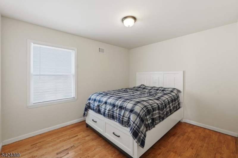 433 Linden Avenue Elizabeth, NJ 07202 - Photo 22 of 33 a bed sitting in a bedroom next to a window
