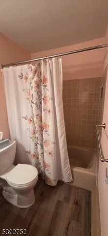 a white toilet sitting next to a bath tub and shower