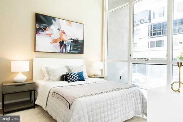 a bedroom with a bed and a painting on the wall