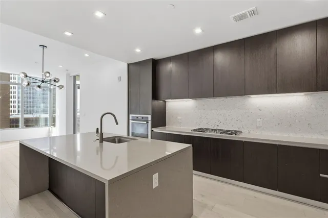 a kitchen with kitchen island stainless steel appliances a sink stove and cabinets