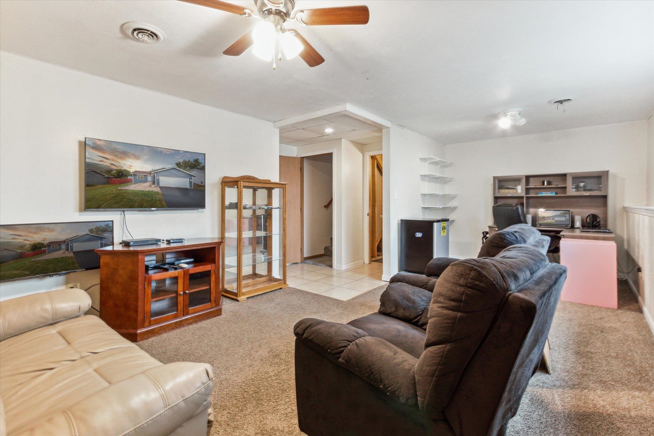 5388 Rockingham Drive Loves Park, IL 61111 - Photo 24 of 38 a living room with furniture a flat screen tv and kitchen view